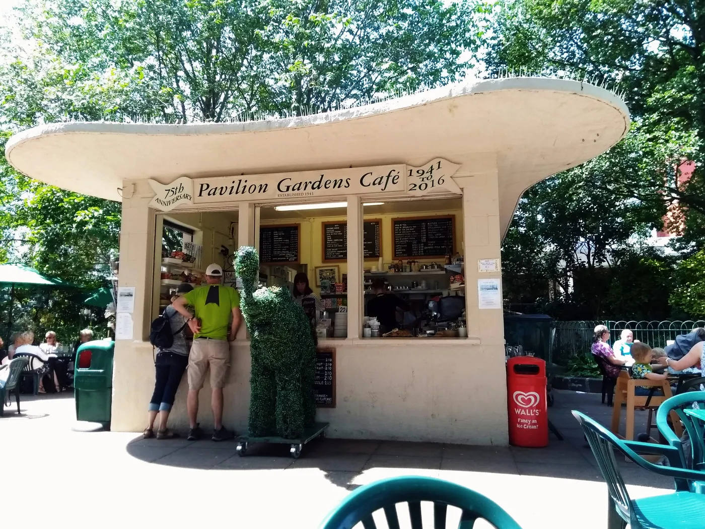 The Pavilion Gardens Café in the Royal Pavilion Gardens, with customers at the counter and tables outside