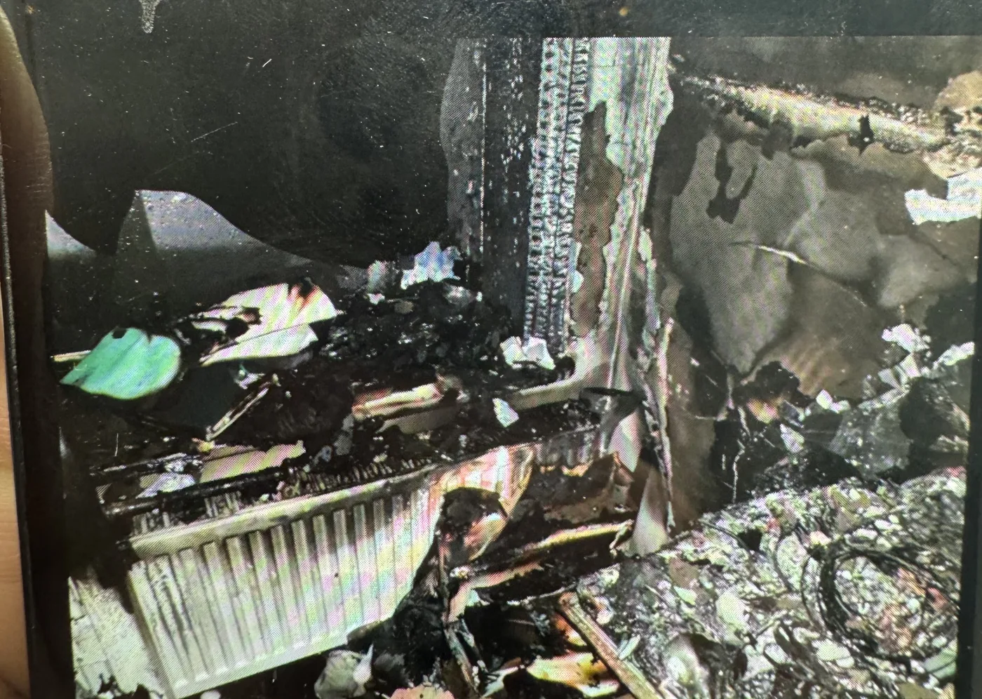 Fire damage to a room in the Brighton residential building, with a scorched radiator and burnt debris