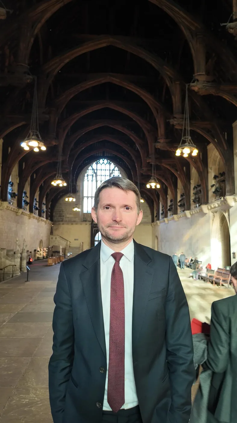 Chris Ward MP standing in Westminster Hall under its timber roof