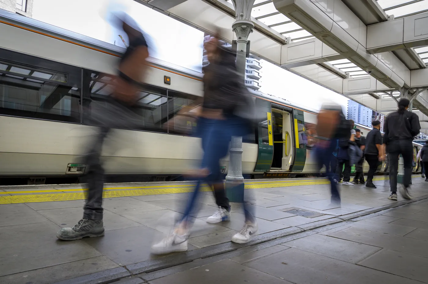 Passengers walking along a platform beside a Southern train